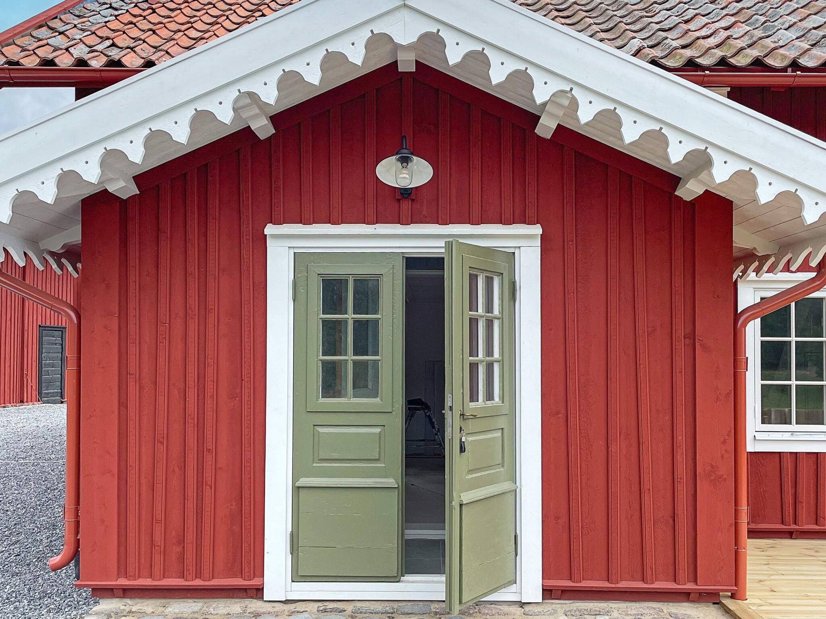 Een rood gebouw met witte accenten en een groene deur.
