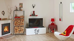 Ett modernt vardagsrum med en öppen spis, en tv och en röd lampa.