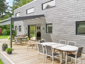 A modern house with a deck, outdoor furniture, and a fire pit. - 5 Star Holiday Home in Vig (Vig)