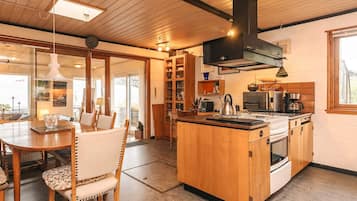 A kitchen with a central island, wooden cabinets, and a stove.