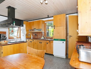 A compact kitchen with wooden cabinets, a built-in stove, and a dishwasher. - 5 Person Holiday Home in Hesselager (Hesselager)