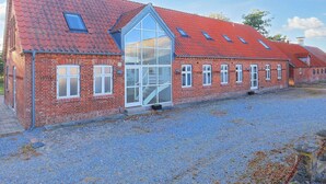 A red brick building with a large glass window and multiple smaller windows.