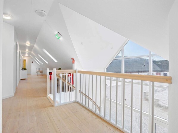 A modern interior with a wooden floor, white walls, and a sloped ceiling. - 20 Person Holiday Home in Saeby (Sæby)
