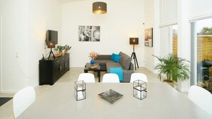 A modern living room with a dining table, sofa, and a television. - 5 Person Holiday Home in Gilleleje (Gilleleje)