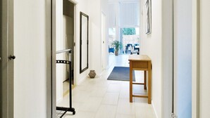 A hallway with a wooden bench, a mirror, and a door leading to a room. - 5 Person Holiday Home in Gilleleje (Gilleleje)