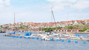 A marina with boats docked, surrounded by red-roofed houses. - 4 Person Holiday Home in Kungshamn (Kungshamn)