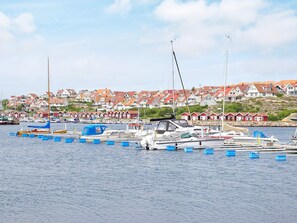 Un port de plaisance où sont amarrés des bateaux, entouré de maisons aux toits rouges.