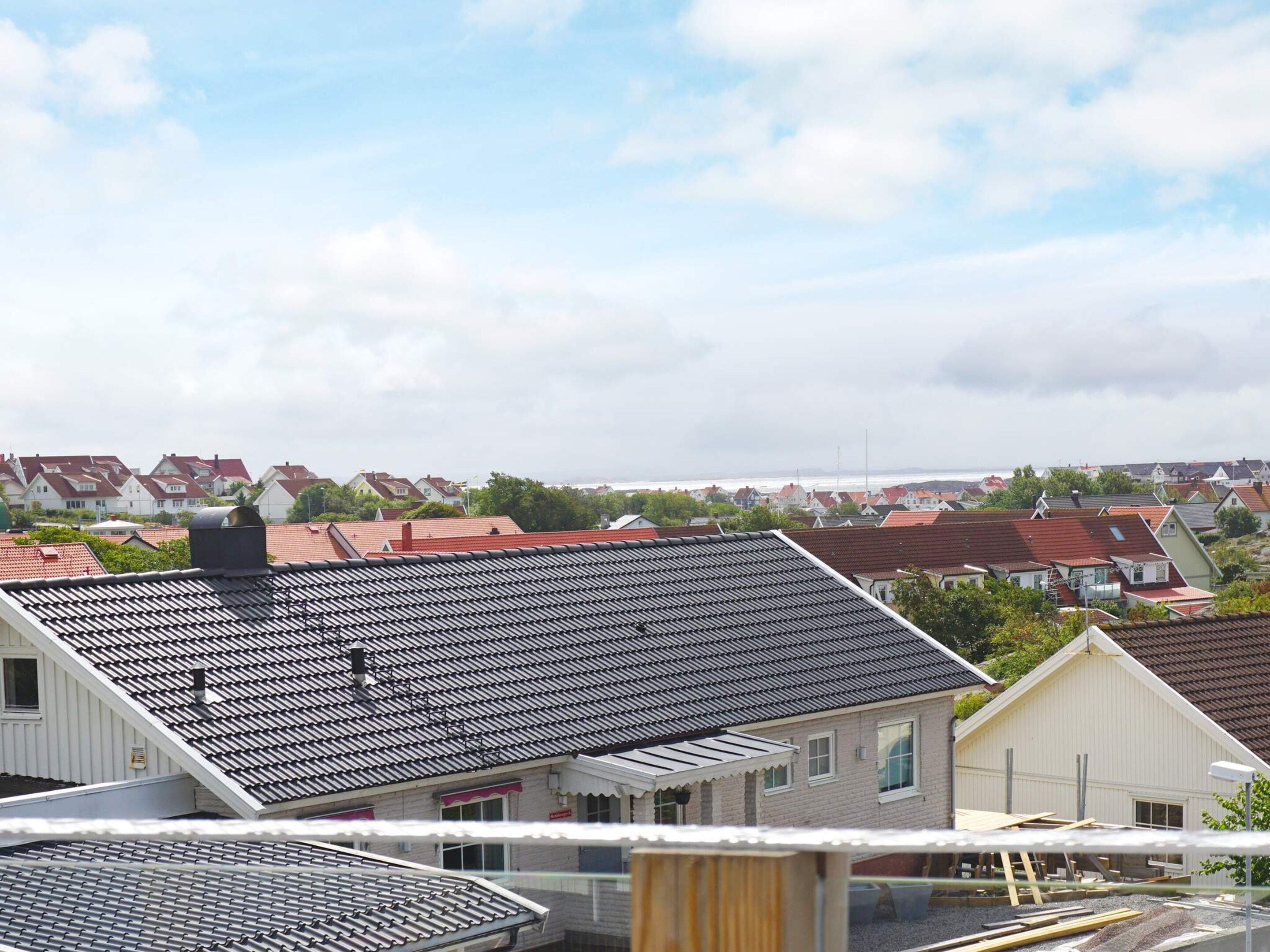Een woonwijk met huizen, een heldere lucht en uitzicht op zee.