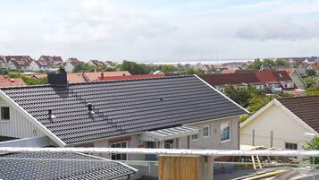 Een woonwijk met huizen, een heldere lucht en uitzicht op zee.