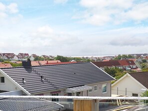 Un quartier résidentiel avec des maisons, un ciel dégagé et une vue sur la mer.