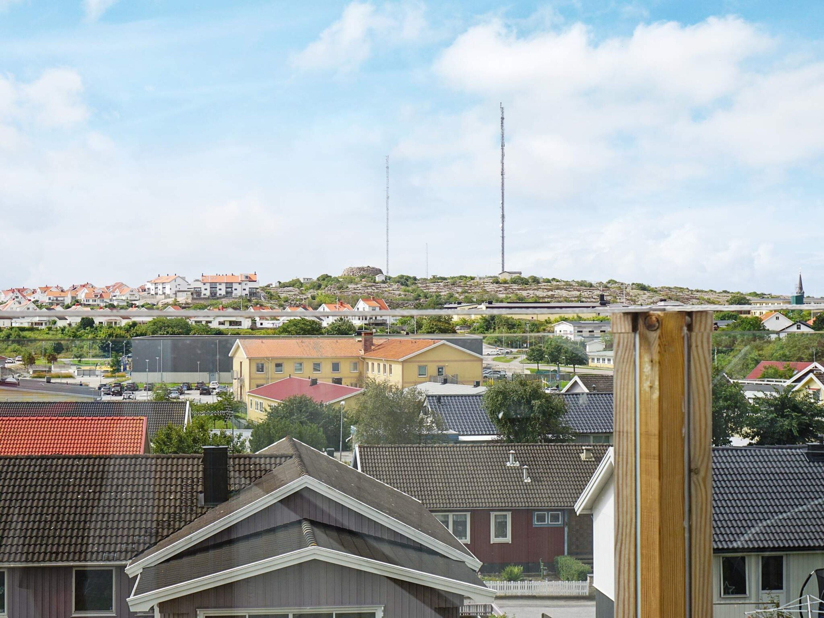 Et boligområde med huse, en bakketop med et kirketårn og et højt kommunikationstårn.