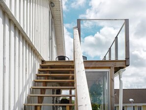 Una escalera conduce a un balcón con vistas a una zona residencial.
