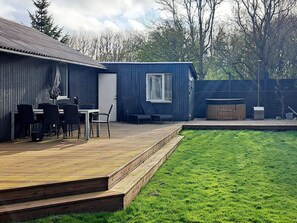 A backyard with a wooden deck, a dining table with chairs, a barbecue grill, and a small shed. - 7 Person Holiday Home in Vestervig (Vestervig)