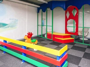 Un área de juegos infantiles con equipo de juego colorido y asientos.