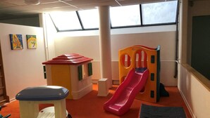 A play area with a slide, a small playhouse, and a bench.