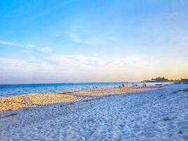 Una playa con cielo despejado y mar tranquilo.