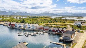 A coastal village with houses by the water, docks, and mountains in the background. - 6 Person Holiday Home in Bud (Averoy)
