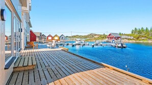 A wooden deck with a view of a marina, boats, and colorful buildings. - 6 Person Holiday Home in Bud (Averoy)