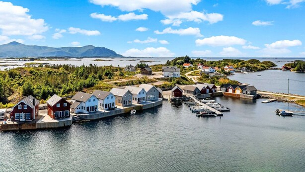A coastal village with houses along the water, a dock, and boats. - 6 Person Holiday Home in Bud (Averoy)
