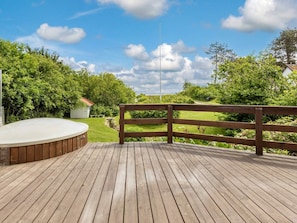 A wooden deck with a hot tub and a wooden fence overlooking a grassy yard. - 5 Star Holiday Home in Hadsund (Hadsund)