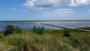 A coastal landscape with a pier extending into the water, surrounded by grassy areas and a clear sky. - 5 Star Holiday Home in Hadsund (Hadsund)