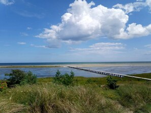 A coastal landscape with a pier extending into the water, surrounded by grassy areas and a clear sky. - 5 Star Holiday Home in Hadsund (Hadsund)