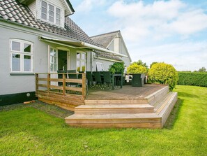 A house with a wooden deck, outdoor furniture, and a well-maintained lawn. - 4 Star Holiday Home in Asperup (Middelfart)