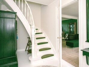 A staircase with white balusters and green steps leading to a room with green walls and a green sofa. - 4 Star Holiday Home in Asperup (Middelfart)