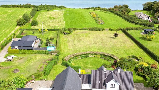 A large estate with multiple buildings, expansive green lawns, and a circular garden feature. - 4 Star Holiday Home in Asperup (Middelfart)