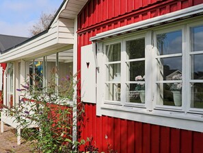 A red and white building with large windows and a white porch.