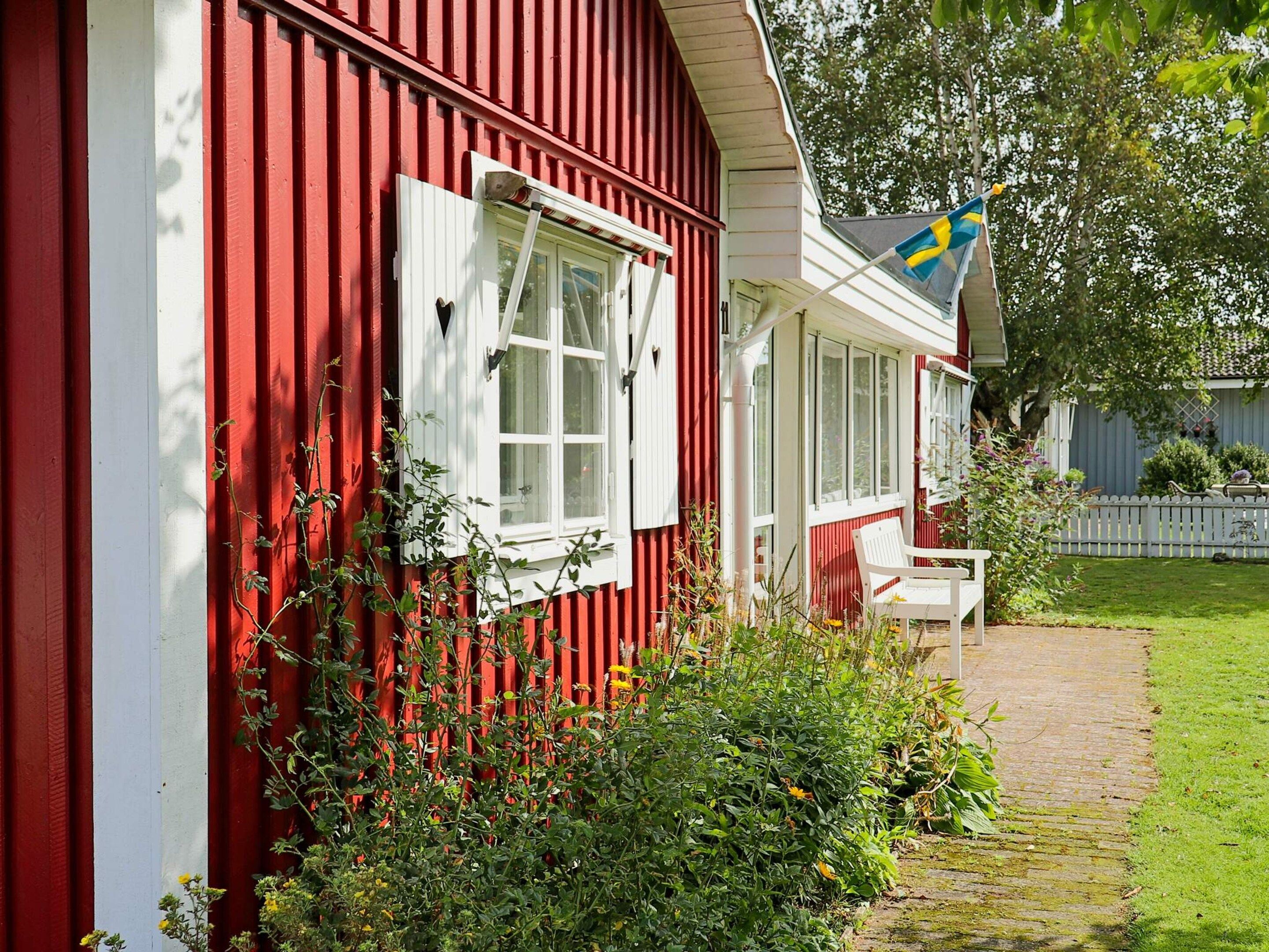 A red building with a white window and a flag.
