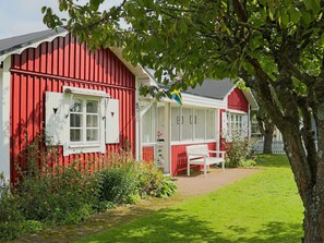 A red and white building with a white bench and a flag.