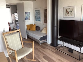 A compact room with a bed, a television, and a chair.