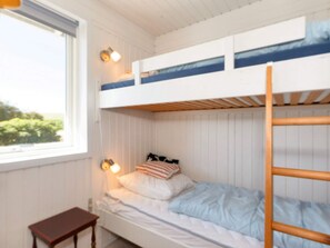 A bunk bed with a wooden ladder, a bedside table, and a window with a view of greenery. - 6 Person Holiday Home in Nykobing M (Nykobing Mors)
