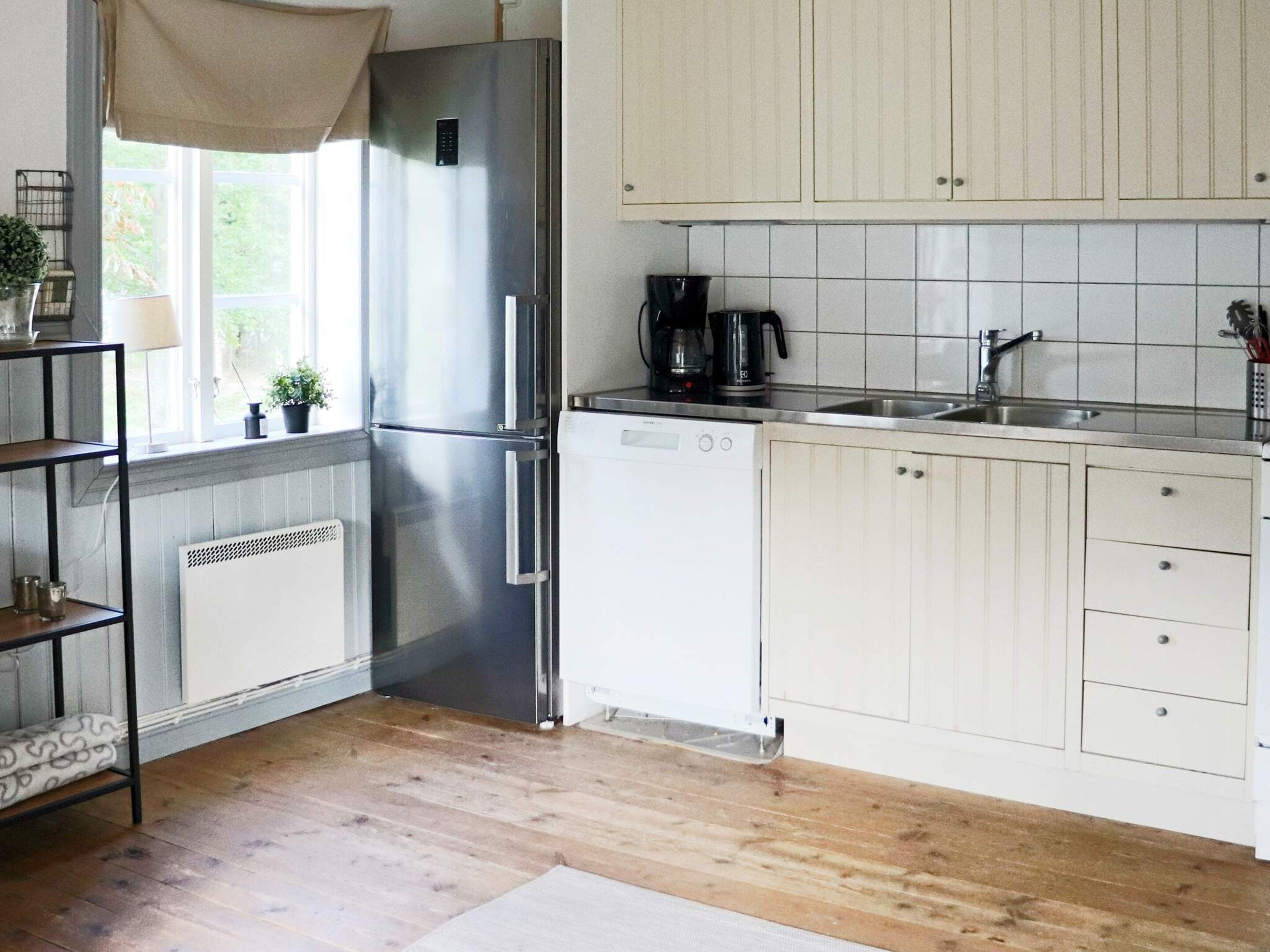 A modern kitchen with a stainless steel refrigerator, a dishwasher, and a coffee maker.