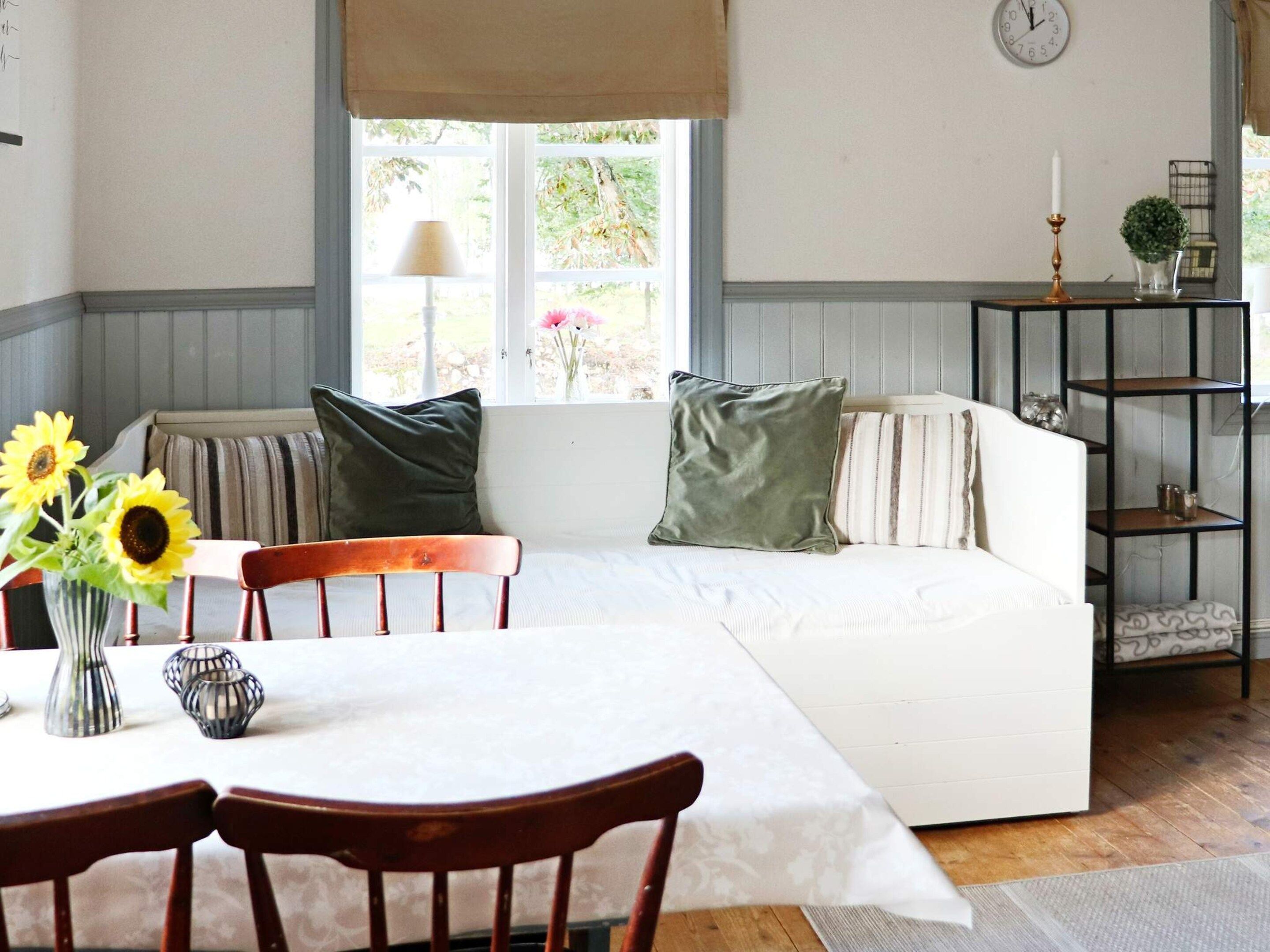 Una habitación acogedora con sofá, sillas, una mesa y un ventanal con vistas a zonas verdes.