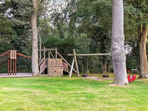 A playground with a wooden climbing structure and swings. - 5 Person Holiday Home in Allinge (Allinge)