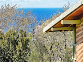 Un edificio con vista al océano y árboles circundantes.