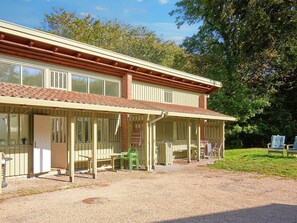 A two-story building with a covered porch, a brick chimney, and a gravel driveway. - 5 Person Holiday Home in Allinge (Allinge)