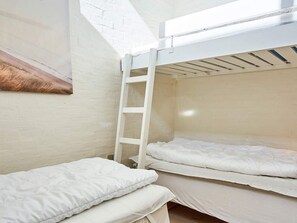 A bunk bed room with a ladder, white walls, and a single bed. - 5 Person Holiday Home in Allinge (Allinge)