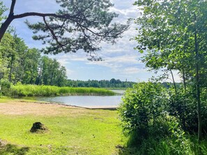 A natural landscape with a body of water, grassy areas, and dense trees. - 4 Star Holiday Home in Rimbo (Rimbo)