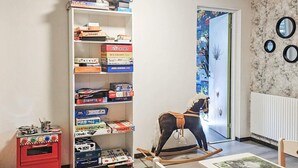 A child's playroom with a bookshelf, a rocking horse, a small table with a painting, and a red storage unit. - 4 Star Holiday Home in Ullared (Ullared)