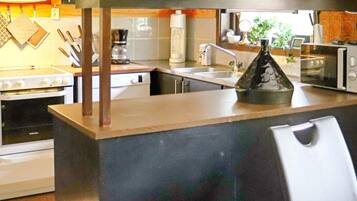 A kitchen with a central island, a stove, a microwave, and a sink.