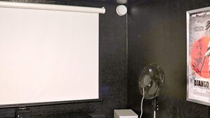 A room with a projector screen, a speaker, and a poster on the wall. - 4 Star Holiday Home in Ullared (Ullared)