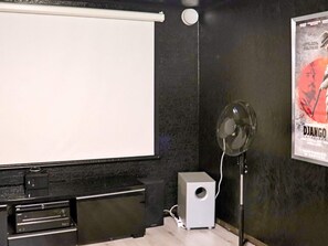 A room with a projector screen, a speaker, and a poster on the wall. - 4 Star Holiday Home in Ullared (Ullared)