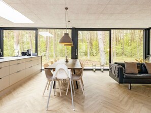 Enjoy meals in the spacious dining area with a large table and comfortable seating, surrounded by stunning forest views.