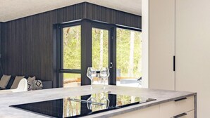Una cocina moderna con una isla central, ventanas amplias y vistas al exterior.