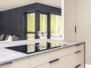 Una cocina moderna con una isla central, ventanas amplias y vistas al exterior.