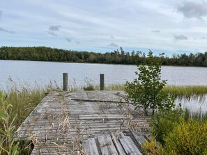 A wooden dock extending into a calm lake, surrounded by dense greenery and trees. - 6 Person Holiday Home in Asarum (Asarum)