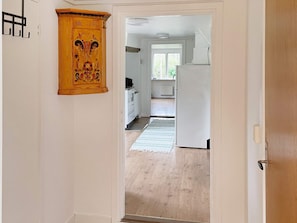 A hallway leading to a kitchen with a wooden cabinet and a white refrigerator. - 6 Person Holiday Home in Asarum (Asarum)